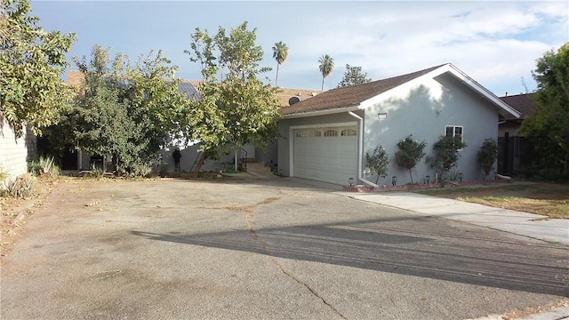 view of front facade with concrete driveway, roof mounted solar panels, an attached garage, and stucco siding