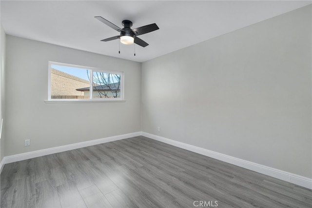 unfurnished room with dark wood-type flooring, baseboards, and a ceiling fan