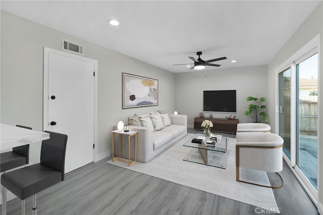 living area with recessed lighting, visible vents, ceiling fan, wood finished floors, and baseboards