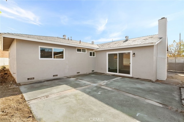 rear view of house featuring crawl space, a patio area, a chimney, and stucco siding