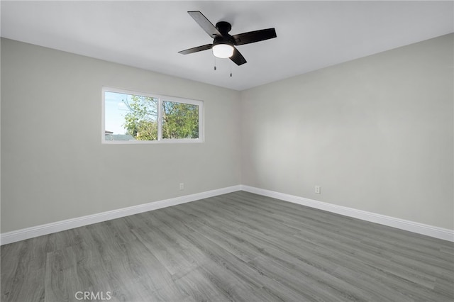 spare room with a ceiling fan, baseboards, and wood finished floors