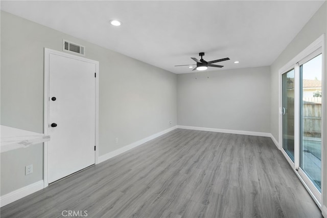 empty room featuring recessed lighting, wood finished floors, visible vents, and baseboards