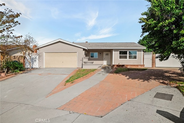 ranch-style house with stucco siding, an attached garage, a gate, fence, and driveway