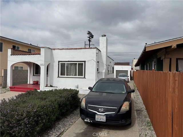 view of side of home featuring fence and stucco siding