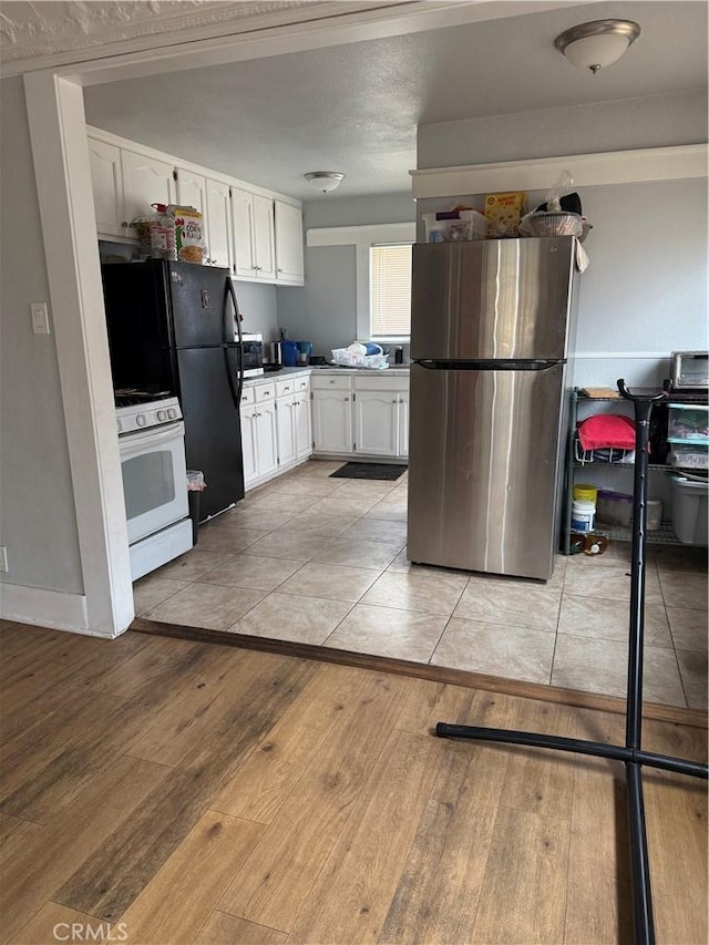 kitchen with stainless steel appliances, white cabinets, and light wood finished floors