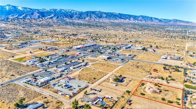 drone / aerial view featuring view of desert and a mountain view