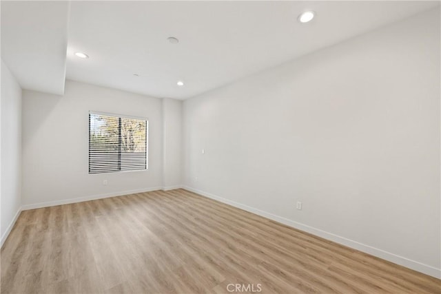 unfurnished room featuring light wood-type flooring, baseboards, and recessed lighting