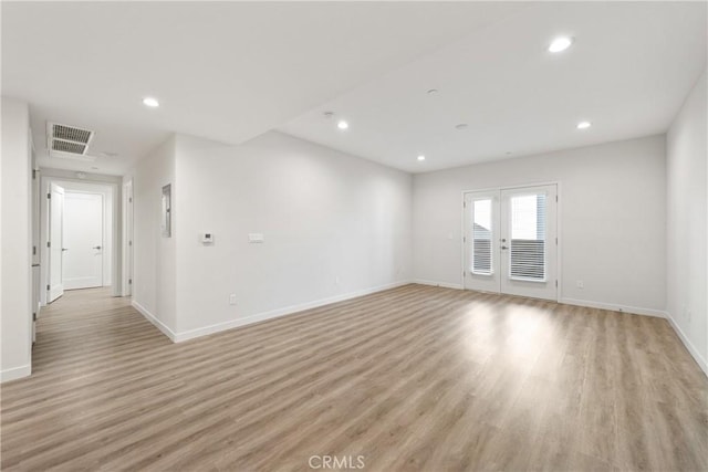 unfurnished room with french doors, light wood finished floors, recessed lighting, visible vents, and baseboards