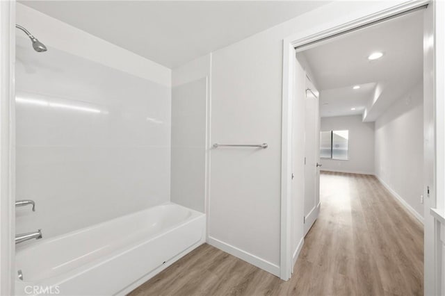 bathroom featuring recessed lighting, baseboards, wood finished floors, and shower / bathing tub combination