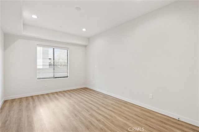 unfurnished room with light wood-type flooring, baseboards, and recessed lighting