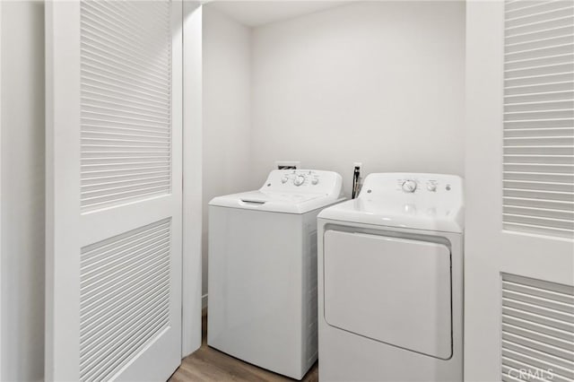 laundry room featuring laundry area, wood finished floors, and independent washer and dryer