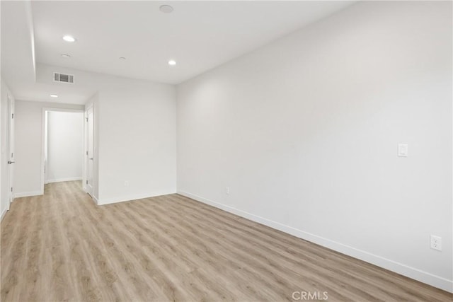 unfurnished room featuring recessed lighting, light wood-type flooring, visible vents, and baseboards