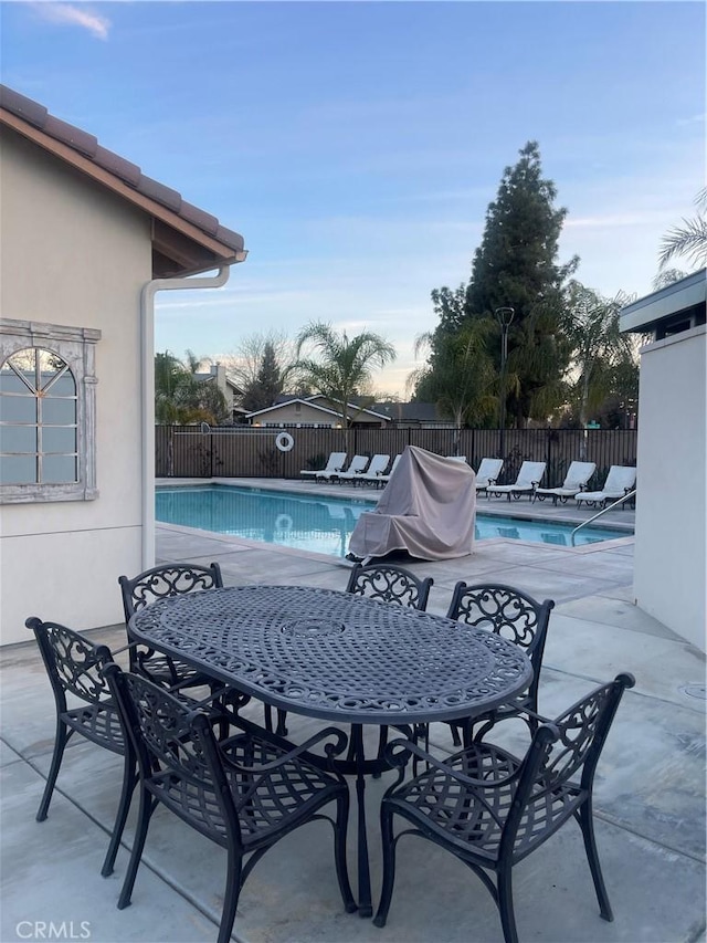 pool featuring fence, outdoor dining area, and a patio