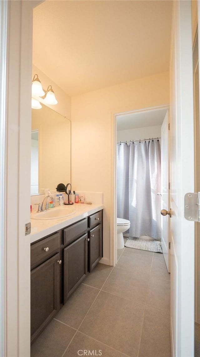 bathroom with tile patterned flooring, vanity, and toilet