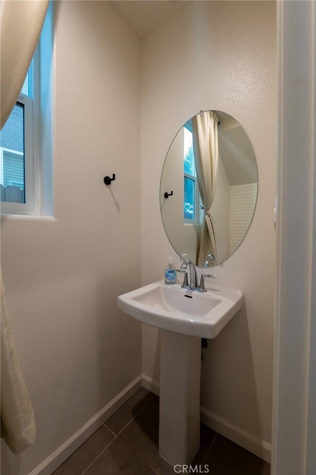 bathroom with tile patterned flooring, baseboards, and a sink