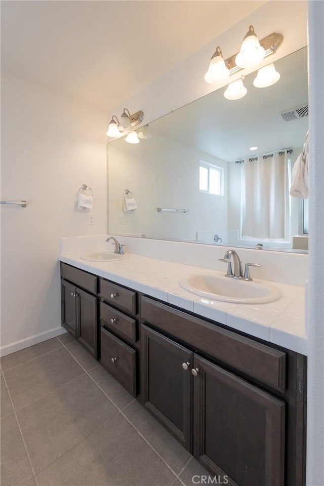 bathroom featuring double vanity, tile patterned flooring, a sink, and visible vents