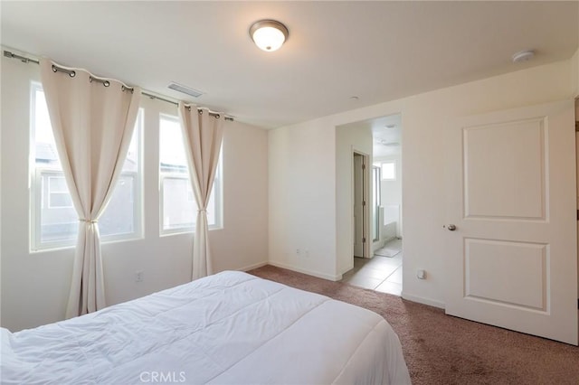 bedroom featuring light carpet, visible vents, and baseboards