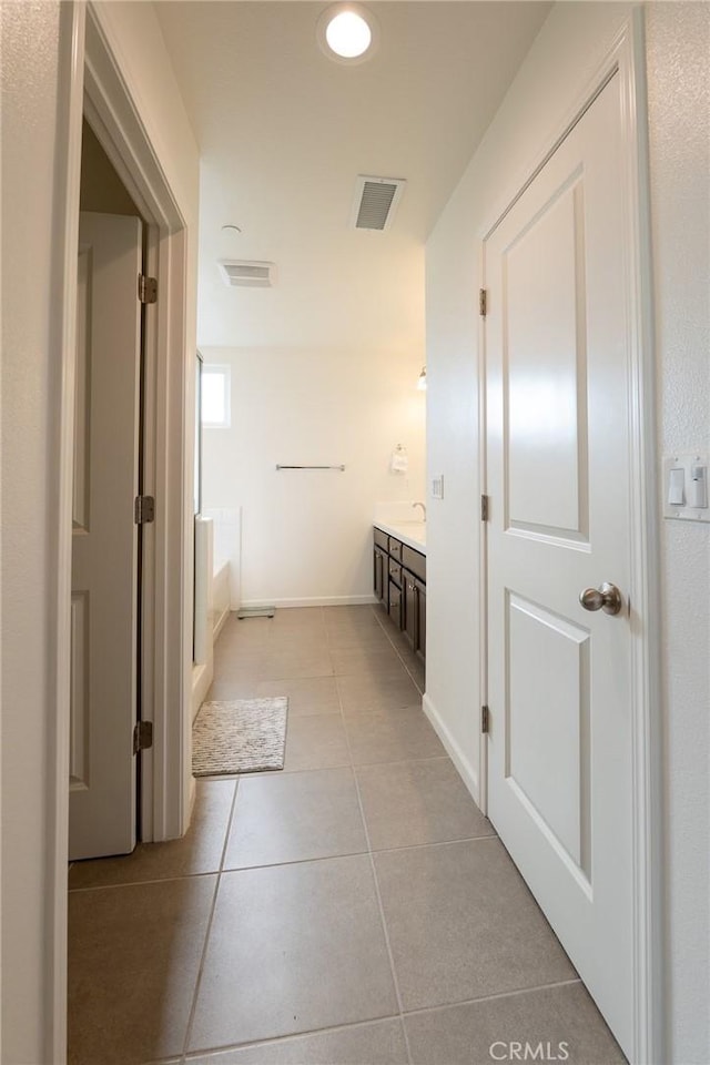 interior space with tile patterned floors, baseboards, visible vents, and vanity