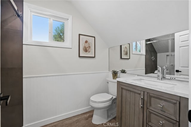 bathroom featuring lofted ceiling, vanity, toilet, and wood finished floors