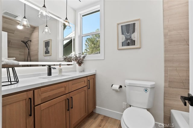 full bathroom featuring visible vents, toilet, wood finished floors, walk in shower, and vanity