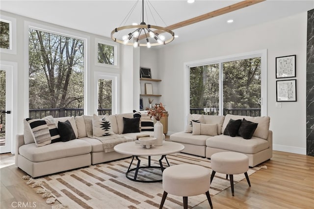 living area with light wood-style floors, recessed lighting, plenty of natural light, and an inviting chandelier