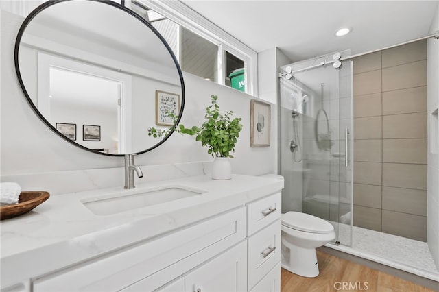 full bathroom with toilet, recessed lighting, wood finished floors, vanity, and a shower stall