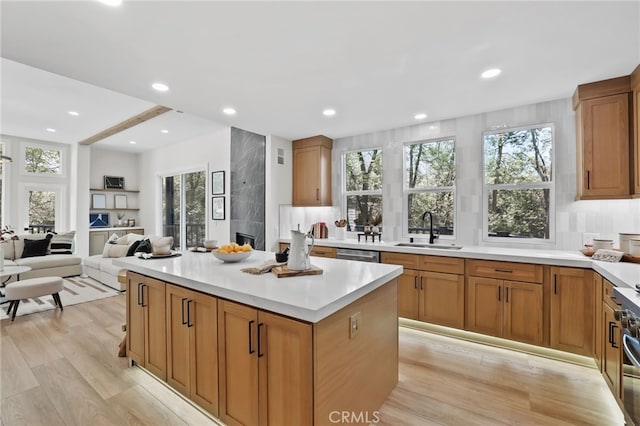 kitchen featuring a center island, light countertops, a sink, and stainless steel dishwasher