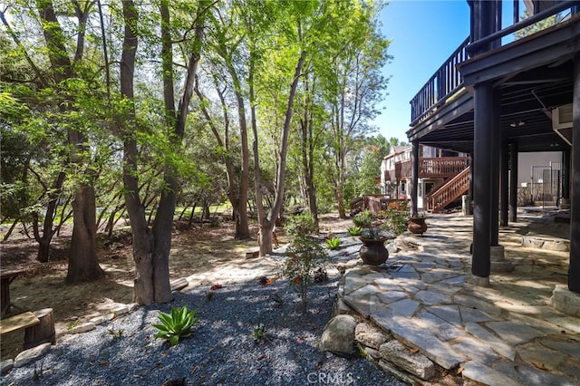 view of yard featuring stairs, a patio area, and a balcony