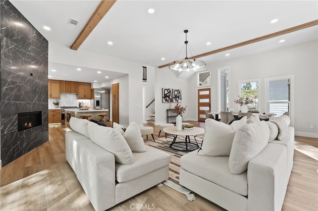 living room featuring light wood-type flooring, recessed lighting, stairway, and a high end fireplace