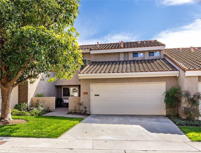 townhome / multi-family property featuring a tile roof, driveway, an attached garage, and stucco siding