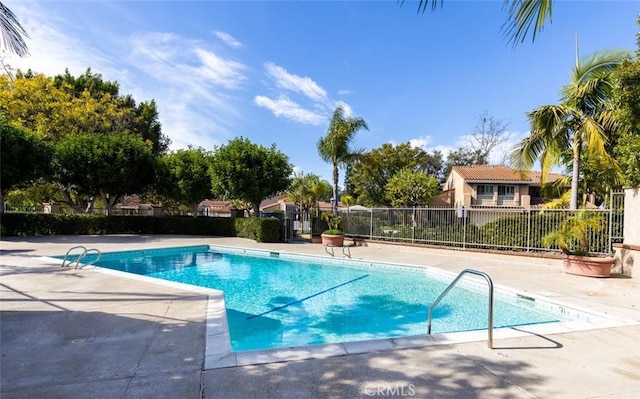 pool with fence and a patio