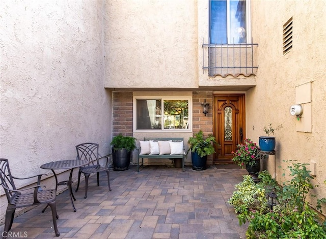 view of exterior entry featuring a patio and stucco siding