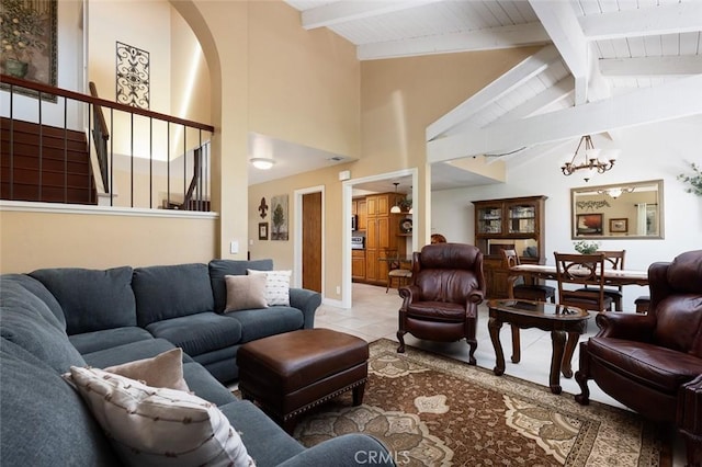 tiled living area featuring lofted ceiling with beams and a notable chandelier