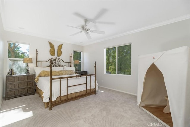 carpeted bedroom with baseboards, a ceiling fan, and crown molding