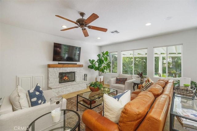 living room featuring recessed lighting, a ceiling fan, visible vents, and a fireplace