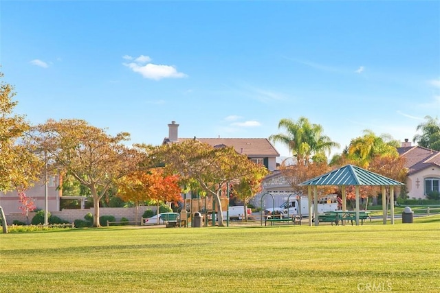 view of community featuring a gazebo, a lawn, and fence