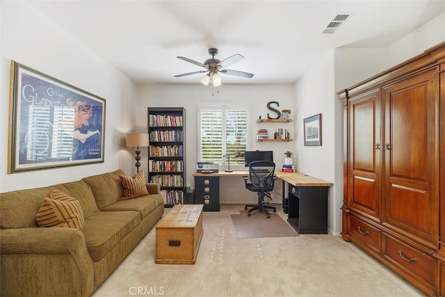 office area with visible vents, a ceiling fan, and light colored carpet