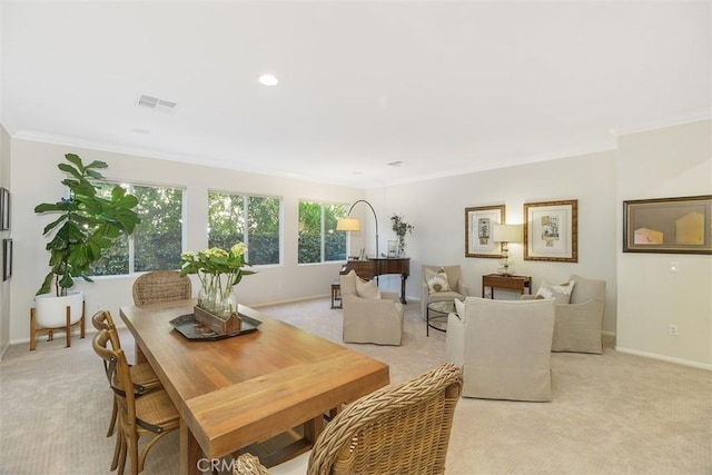 dining space featuring light carpet, ornamental molding, visible vents, and baseboards