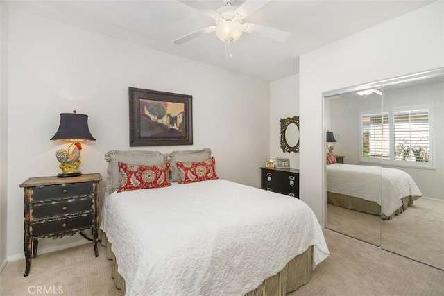 bedroom featuring a closet, ceiling fan, light colored carpet, and baseboards