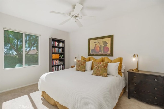 bedroom with ceiling fan, baseboards, and light carpet