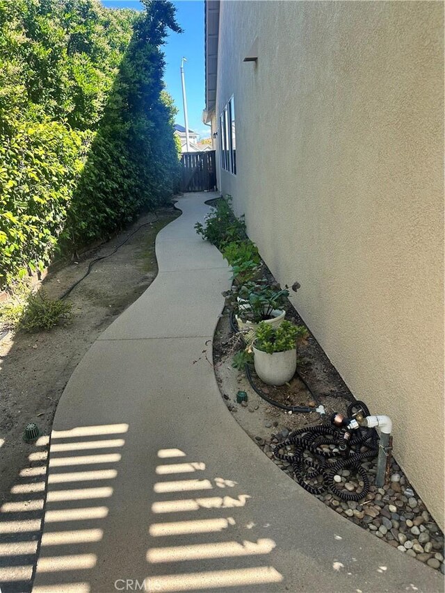 view of side of property featuring fence and stucco siding