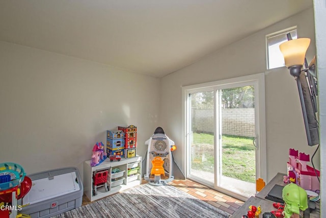 rec room featuring brick floor and vaulted ceiling