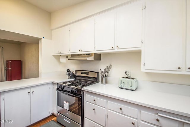 kitchen featuring under cabinet range hood, stainless steel range with gas cooktop, white cabinets, and light countertops