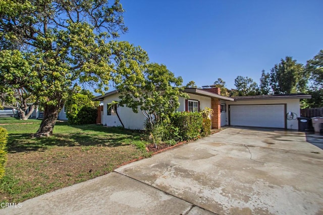 view of front of property featuring a chimney, stucco siding, concrete driveway, an attached garage, and a front lawn