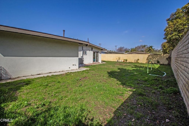 view of yard featuring a fenced backyard and central AC