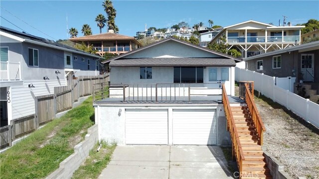 view of front of home featuring a garage, fence, stairs, concrete driveway, and stucco siding