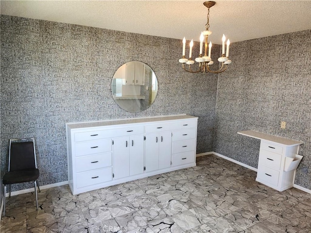 bathroom featuring vanity, a textured ceiling, baseboards, and an inviting chandelier