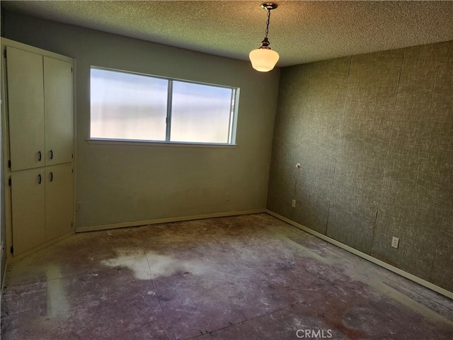 unfurnished room with a textured ceiling