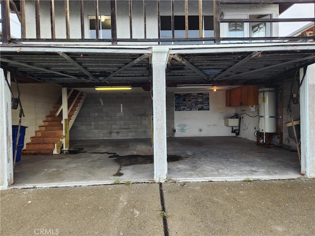 view of vehicle parking featuring stairs and secured water heater