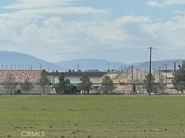 surrounding community with a yard and a mountain view